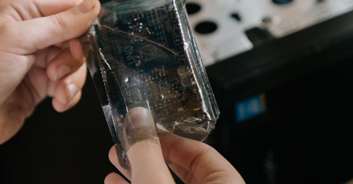 Close-up of hands holding a microchip in a computer repair setting.